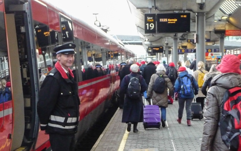 En blid konduktør tar imot de 170 som skal være med til Göteborg. Både togtur og mat var påspandert av NSB. Foto: Ivan Chetwynd.
